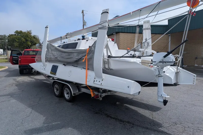 Slide: The Image of 2025 Corsair 760 sailboat on trailer, parked near a red truck. - 6