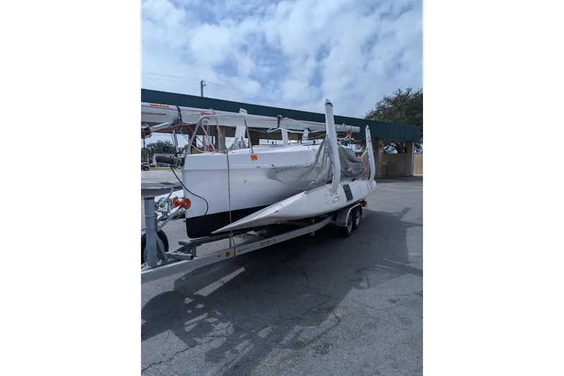 Slide: The Image of 2025 Corsair 760 sailboat on trailer, parked outdoors under cloudy sky. - 7