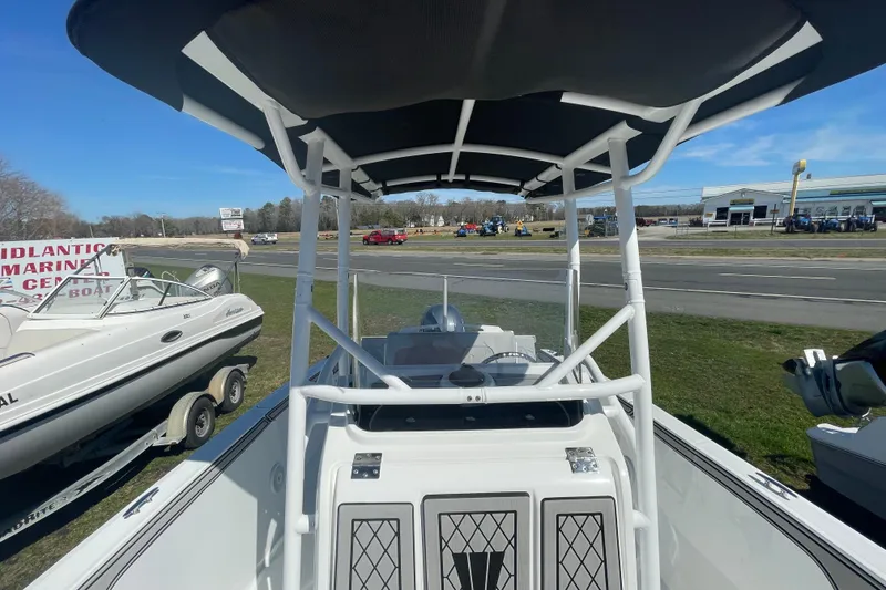 Slide: The Image of 2022 Wellcraft 202 Fisherman boat with T-top, displayed outdoors at a marine center. - 10