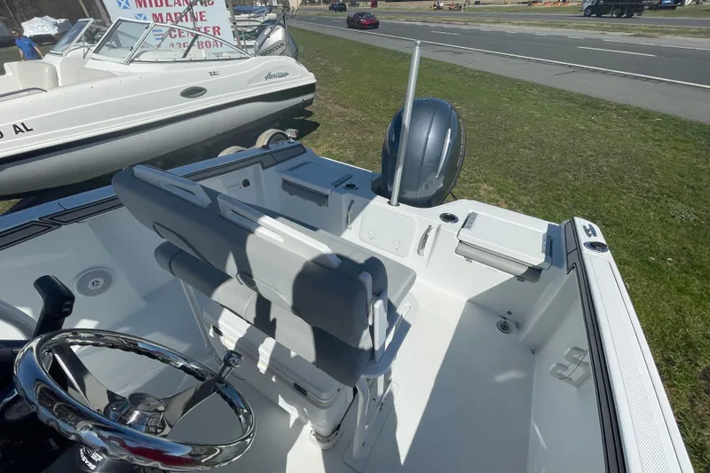 Slide: The Image of 2022 Wellcraft 202 Fisherman boat interior with steering wheel and seating, displayed outdoors. - 16