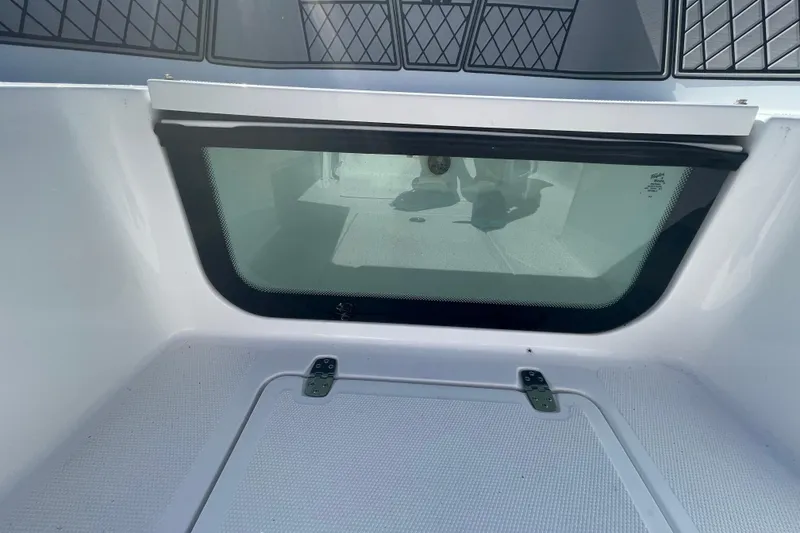 Slide: The Image of 2022 Wellcraft 202 Fisherman boat interior with storage compartment and window. - 2