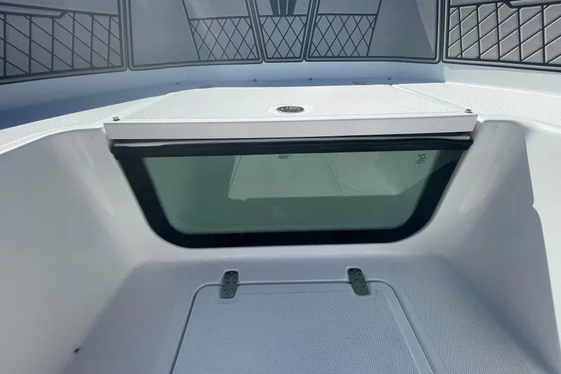 Slide: The Image of 2022 Wellcraft 202 Fisherman boat interior with storage compartment and cushioned seating. - 6