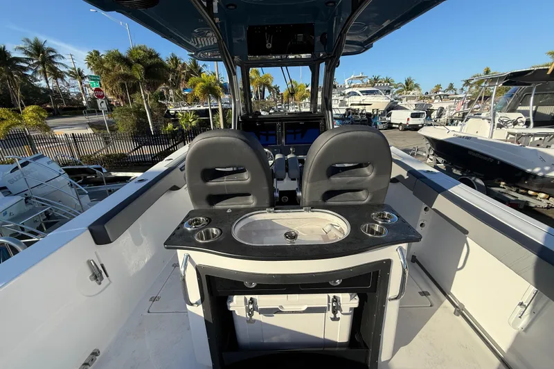 Slide: The Image of 2026 Sea Pro 292 DLX boat interior with helm, seating, and cup holders in a marina setting. - 13