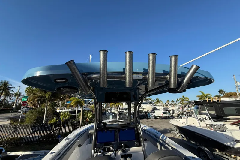 Slide: The Image of 2026 Sea Pro 292 DLX boat with rod holders, docked under clear blue sky. - 14