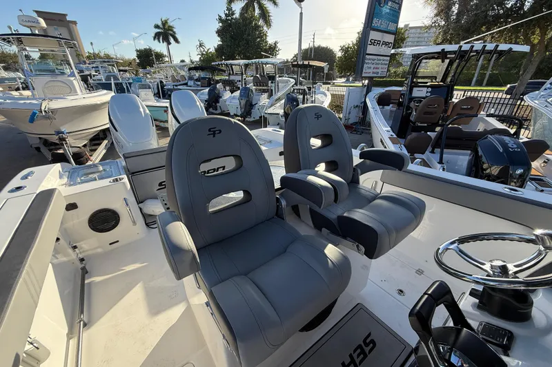 Slide: The Image of 2026 Sea Pro 292 DLX boat interior with dual captain chairs and steering wheel. - 15