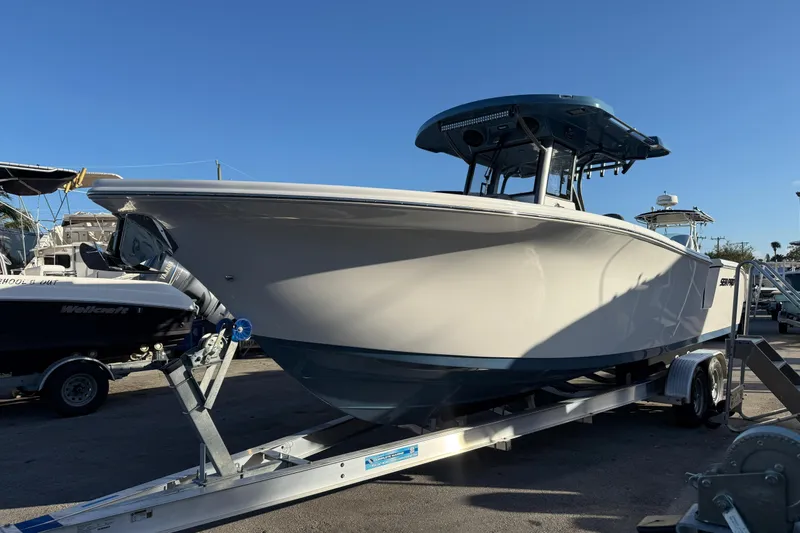 Slide: The Image of 2026 Sea Pro 292 DLX boat on trailer under clear blue sky. - 2