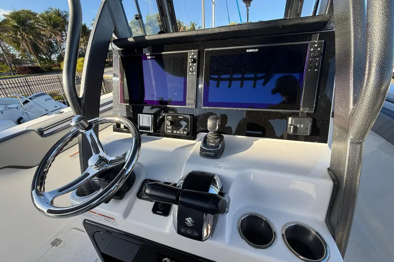 Slide: The Image of 2026 Sea Pro 292 DLX boat dashboard with steering wheel and dual Simrad displays. - 20