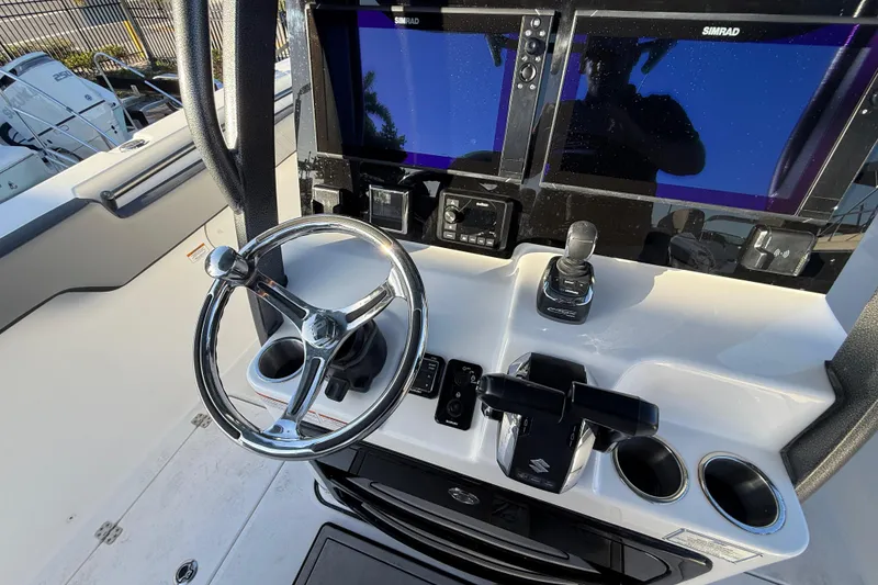 Slide: The Image of 2026 Sea Pro 292 DLX boat dashboard with steering wheel and dual Simrad displays. - 24