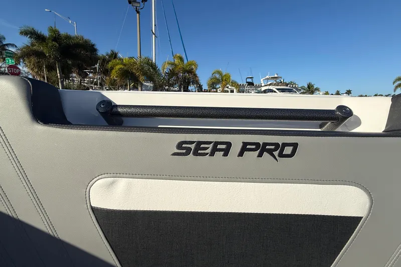 Slide: The Image of 2026 Sea Pro 292 DLX boat interior with logo, palm trees, and clear blue sky. - 34