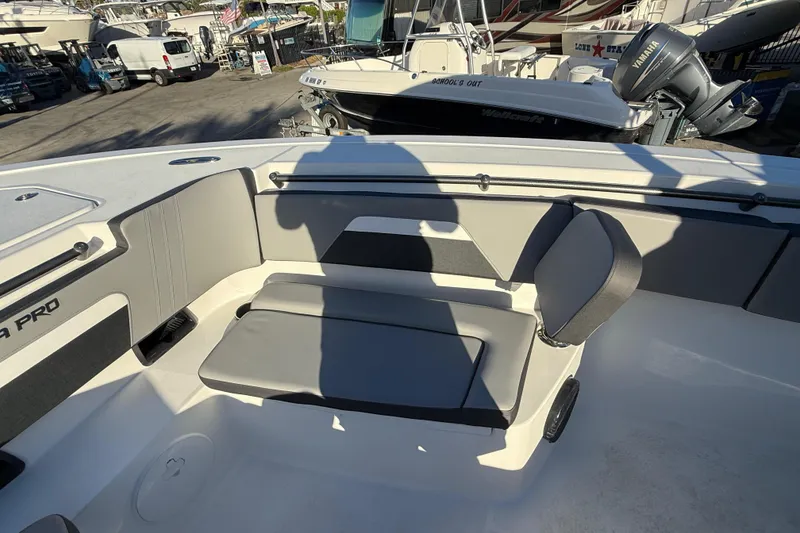 Slide: The Image of 2026 Sea Pro 292 DLX boat interior with cushioned seating and shadow. - 39