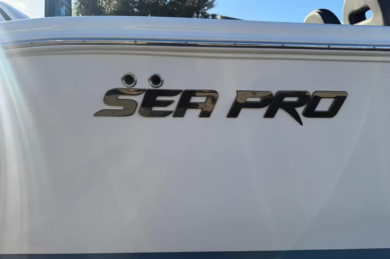 Slide: The Image of 2026 Sea Pro 292 DLX boat logo on white hull, sunlight reflecting. - 4