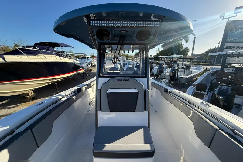 Slide: The Image of 2026 Sea Pro 292 DLX boat interior with seating and console, displayed outdoors. - 40