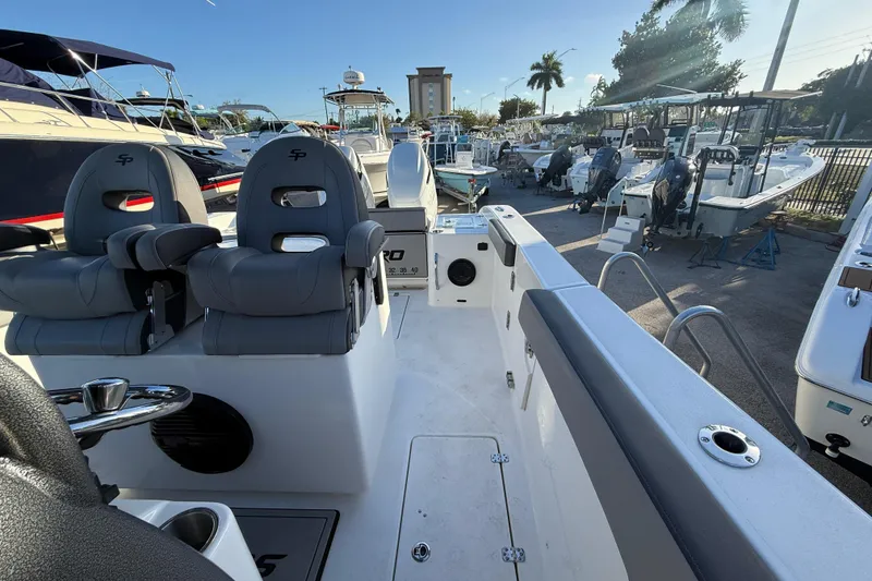 Slide: The Image of 2026 Sea Pro 292 DLX boat interior with dual seats, docked among other boats. - 49