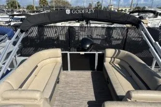Slide: The Image of 2022 Godfrey Sweetwater 2286 C pontoon boat interior with beige seating and black canopy. - 13