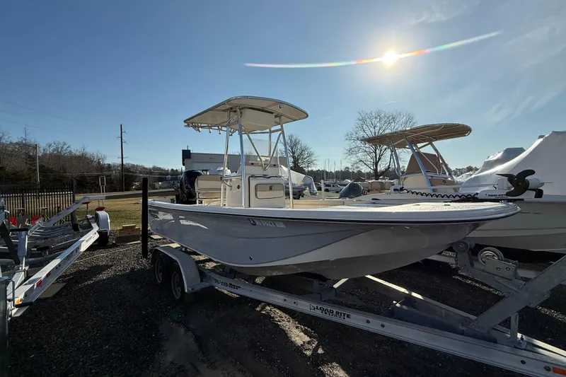 The Image of 2022 Carolina Skiff 21LS boat on trailer under bright sun. - 0