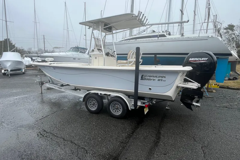 Slide: The Image of 2022 Carolina Skiff 21LS boat on trailer, parked in marina with other boats. - 10