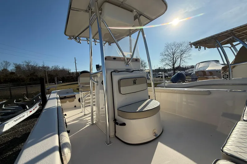 Slide: The Image of 2022 Carolina Skiff 21LS boat interior with seating and T-top under sunny sky. - 4