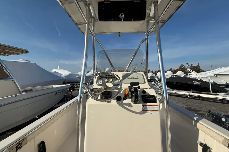 Slide: The Image of 2022 Carolina Skiff 21LS boat console with Garmin navigation, docked under clear blue sky. - 5