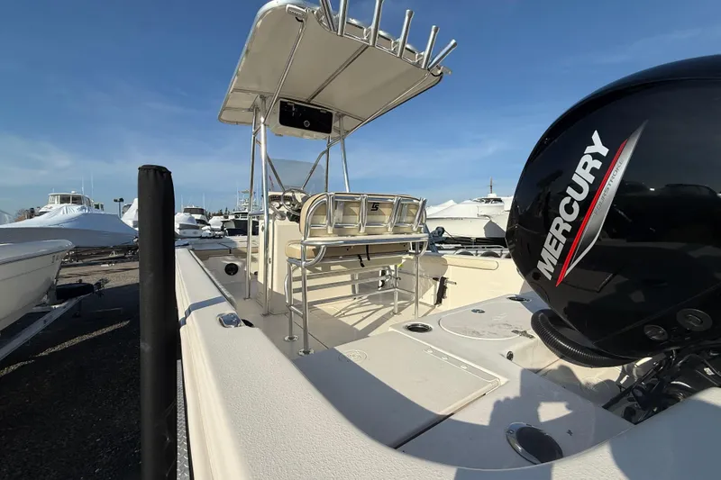 Slide: The Image of 2022 Carolina Skiff 21LS boat with Mercury engine, docked under clear blue sky. - 7