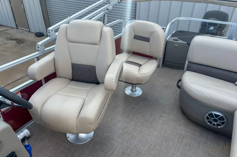 Slide: The Image of 2024 Sun Tracker Bass Buggy 18 DLX interior with beige seating and modern design. - 11