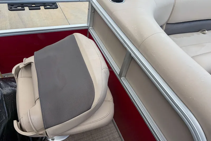 Slide: The Image of 2024 Sun Tracker Bass Buggy 18 DLX boat interior with beige seating and red paneling. - 13
