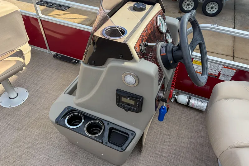 Slide: The Image of 2024 Sun Tracker Bass Buggy 18 DLX boat console with steering wheel and controls. - 14