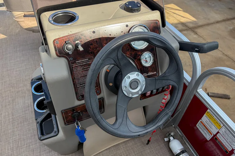 Slide: The Image of 2024 Sun Tracker Bass Buggy 18 DLX steering console with gauges and controls. - 15