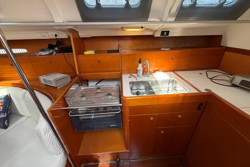 Slide: The Image of Interior of 1996 Beneteau First 42s7 yacht kitchen with stove, sink, and wooden cabinetry. - 16