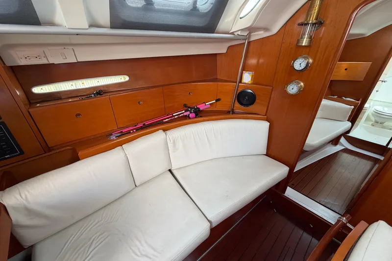 Slide: The Image of Interior of 1996 Beneteau First 42s7 yacht with white seating and wooden cabinetry. - 17