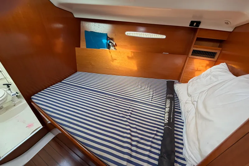 Slide: The Image of Cozy cabin interior of a 1996 Beneteau First 42s7 sailboat with striped bedding. - 18