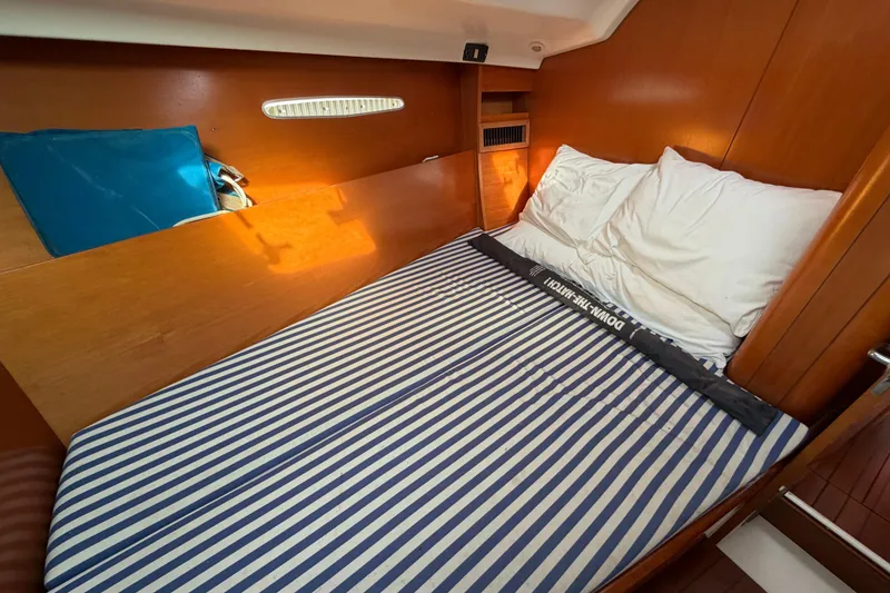 Slide: The Image of Cozy cabin interior of 1996 Beneteau First 42s7 sailboat with striped bedding. - 19