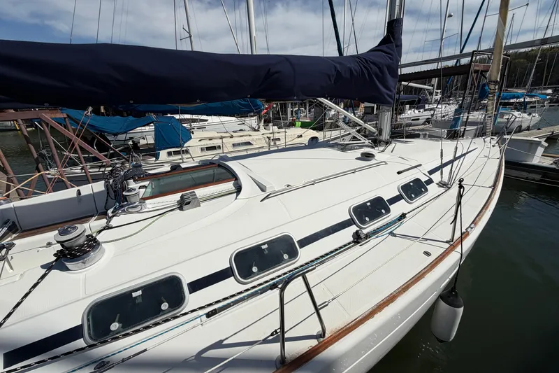 Slide: The Image of 1996 Beneteau First 42s7 sailboat docked at marina, showcasing sleek deck design. - 3