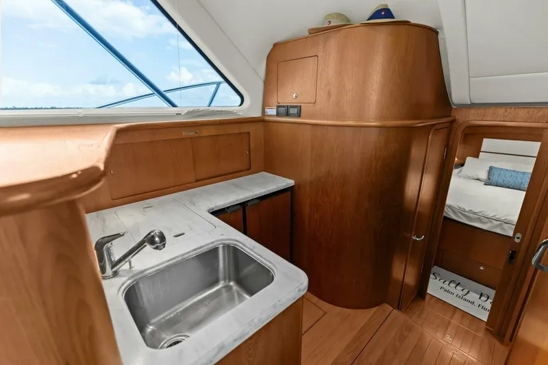 Slide: The Image of 2013 Tiara Yachts 3900 Convertible interior with wooden cabinetry and stainless steel sink. - 21