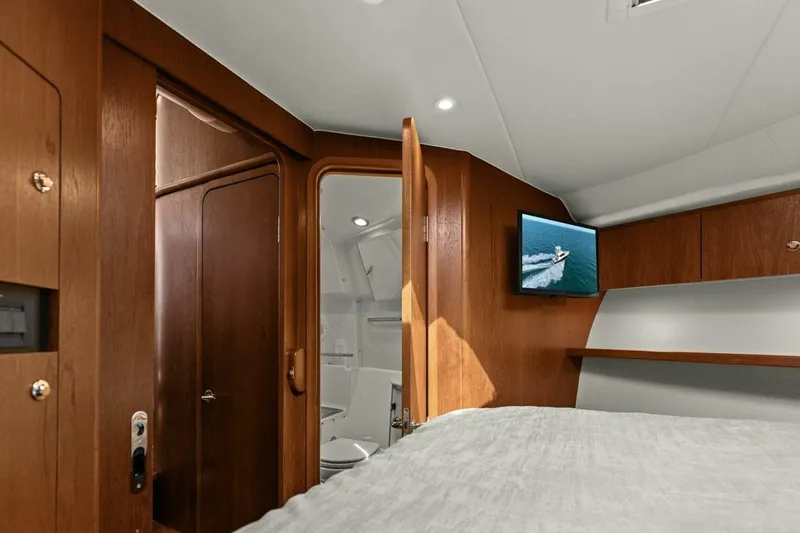 Slide: The Image of Interior of 2013 Tiara Yachts 3900 Convertible, featuring wood cabinetry and a mounted TV. - 23