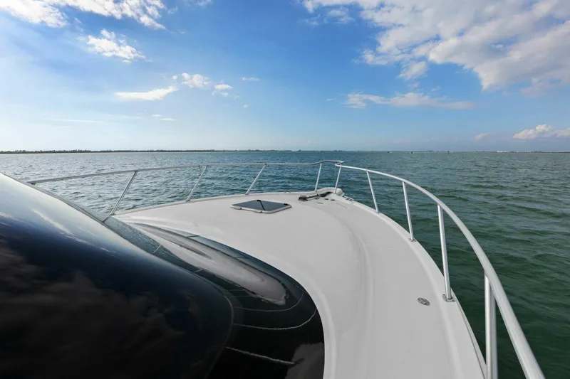 Slide: The Image of 2013 Tiara Yachts 3900 Convertible cruising on open water under a clear blue sky. - 32