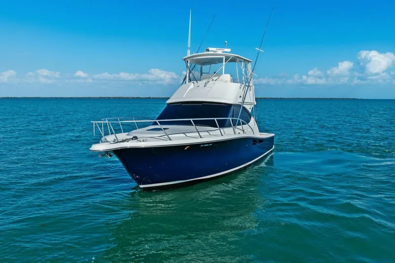 Slide: The Image of 2013 Tiara Yachts 3900 Convertible on open water under clear blue sky. - 53