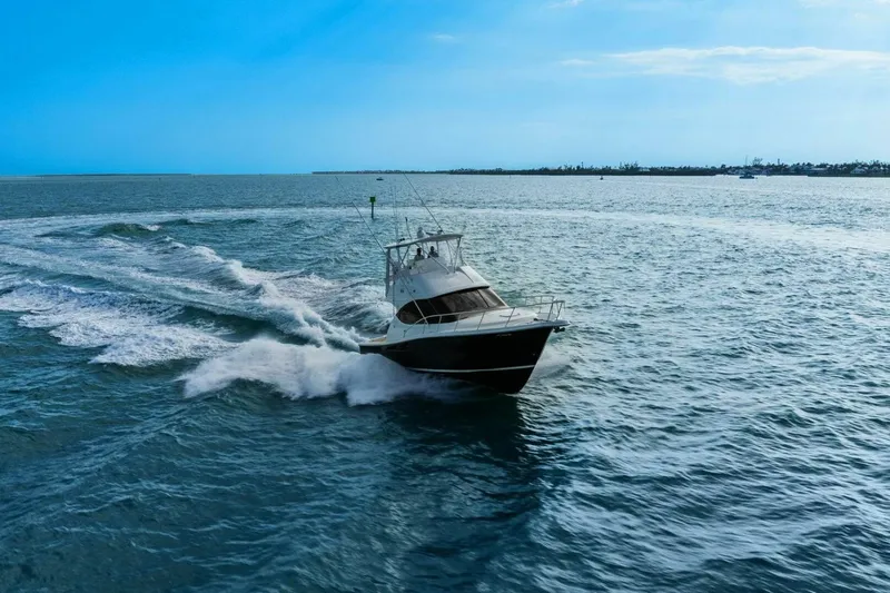 Slide: The Image of 2013 Tiara Yachts 3900 Convertible cruising on open water under clear blue skies. - 62
