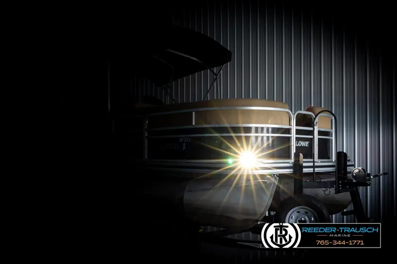 Slide: The Image of 2019 Lowe SF 212 Sport Fish pontoon boat in dimly lit storage, spotlight shining. - 4
