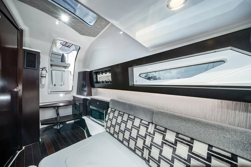 Slide: The Image of 2022 Pursuit S 428 Sport boat with covered seating area, docked in a scenic marina. - 19