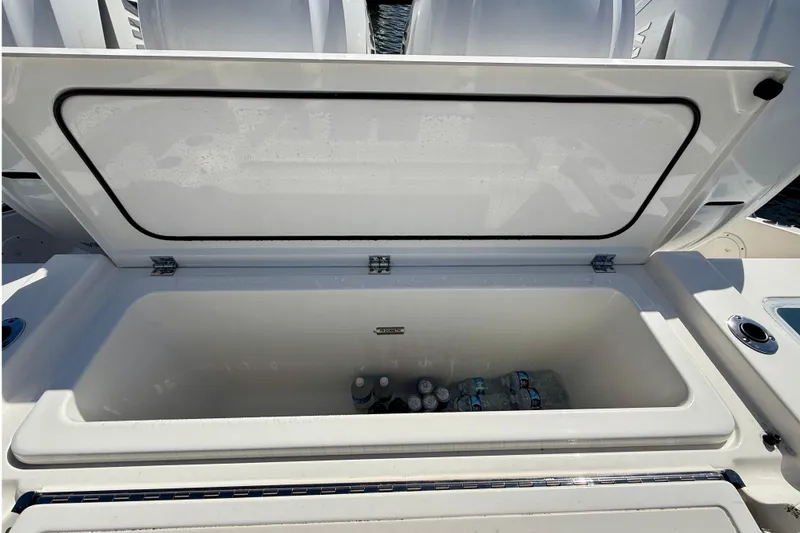 Slide: The Image of Open storage compartment on 2022 Pursuit S 428 Sport boat with bottled drinks inside. - 27