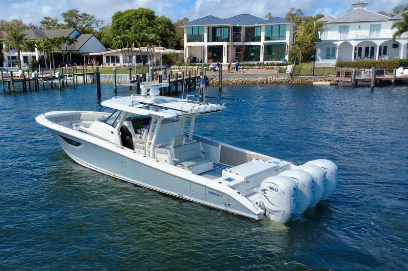 Slide: The Image of 2022 Pursuit S 428 Sport boat cruising near waterfront homes. - 3