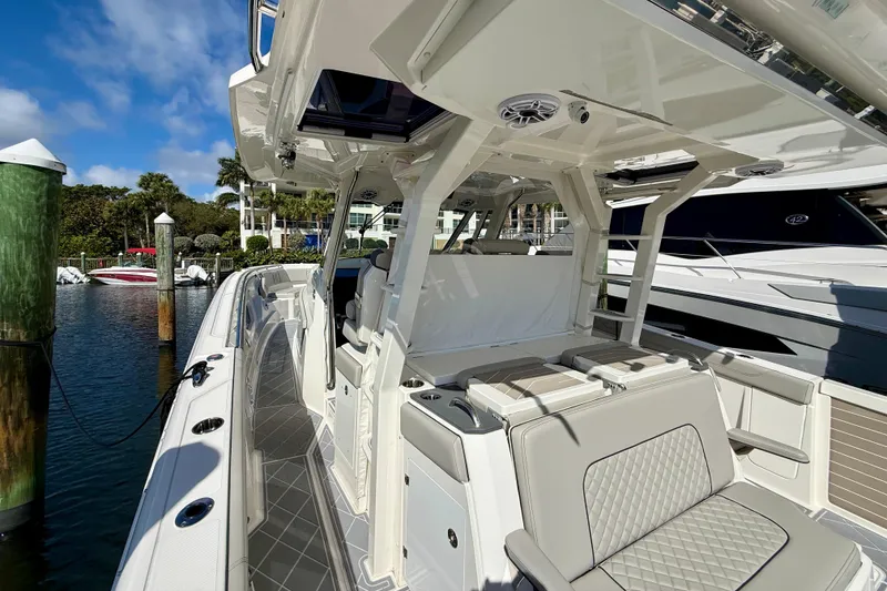Slide: The Image of 2022 Pursuit S 428 Sport boat docked, featuring luxurious seating and sleek design. - 33