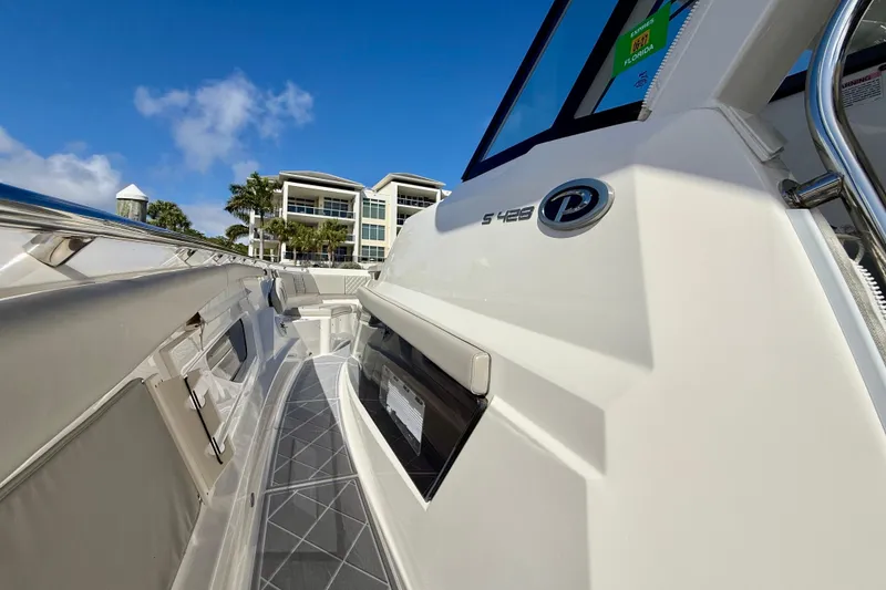 Slide: The Image of 2022 Pursuit S 428 Sport boat docked near modern waterfront buildings. - 45