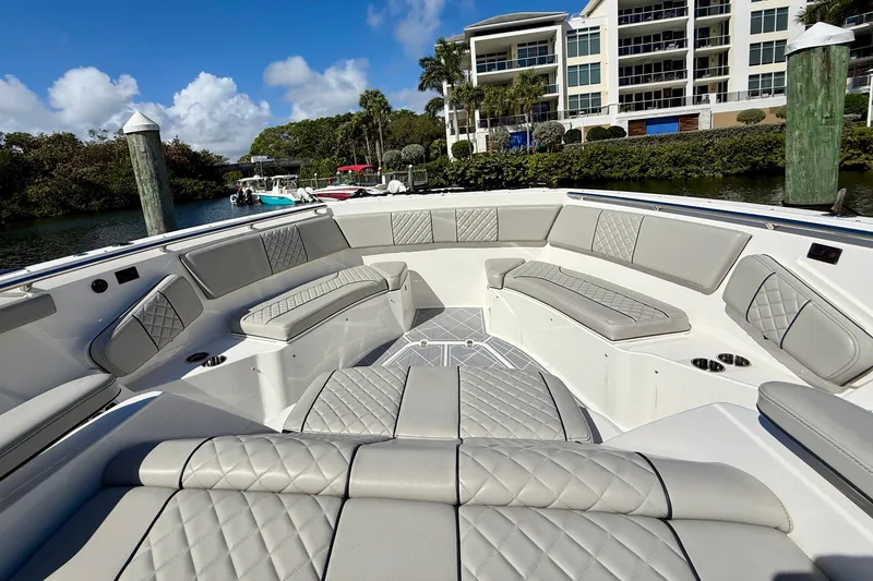 Slide: The Image of Luxurious seating area on 2022 Pursuit S 428 Sport boat, docked near waterfront buildings. - 48