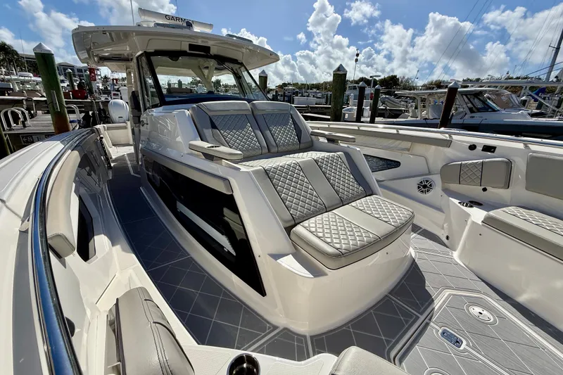Slide: The Image of 2022 Pursuit S 428 Sport boat with luxurious seating and sleek design at a marina. - 51