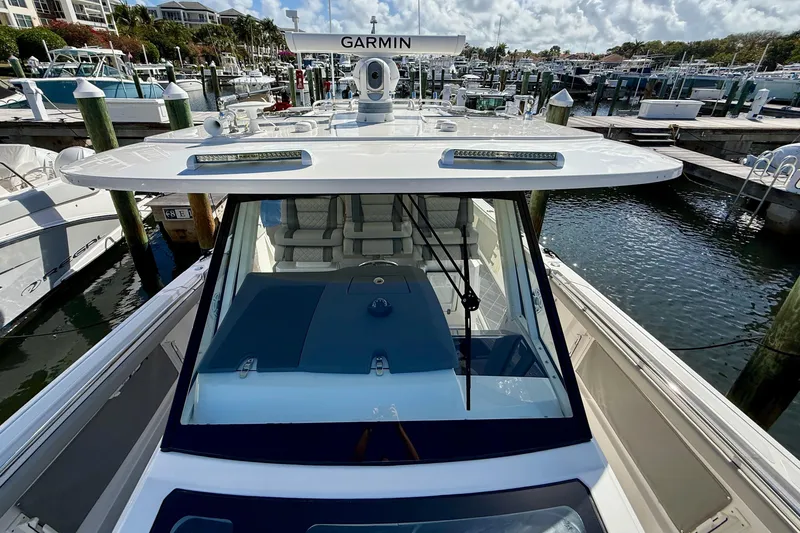 Slide: The Image of 2022 Pursuit S 428 Sport boat docked at marina, featuring Garmin equipment. - 52