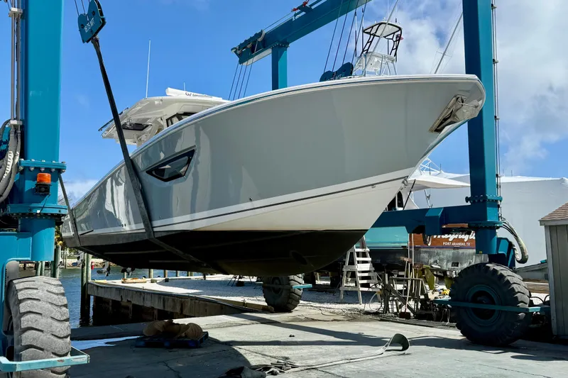 Slide: The Image of 2022 Pursuit S 428 Sport boat lifted on dock with blue sky background. - 62