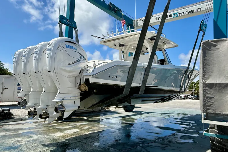 Slide: The Image of 2022 Pursuit S 428 Sport boat with Yamaha engines on a lift under blue sky. - 63