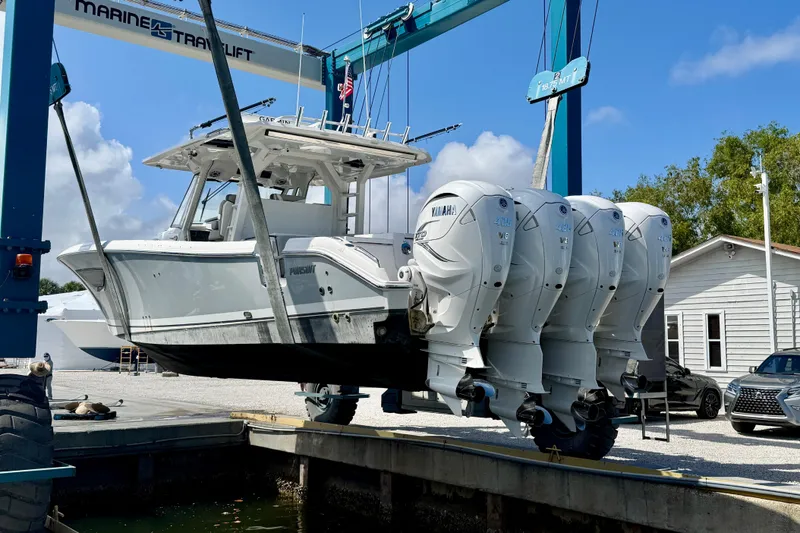 Slide: The Image of 2022 Pursuit S 428 Sport boat with four Yamaha engines on a lift. - 64