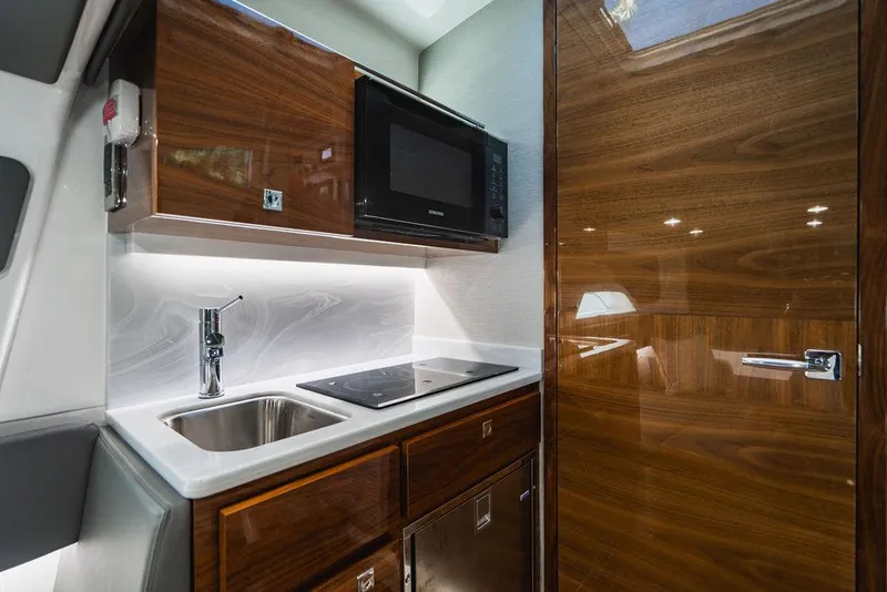 Slide: The Image of 2023 Valhalla V-46 boat interior kitchen with sink, stove, and microwave. - 16